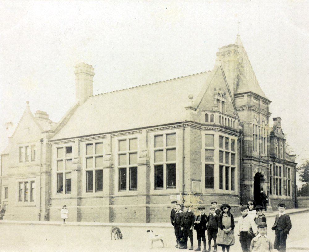 Black and white photograph of Hucknall Library with children and dogs in the foreground