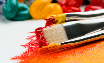 Paint brushes with orange and yellow acrylic paint on