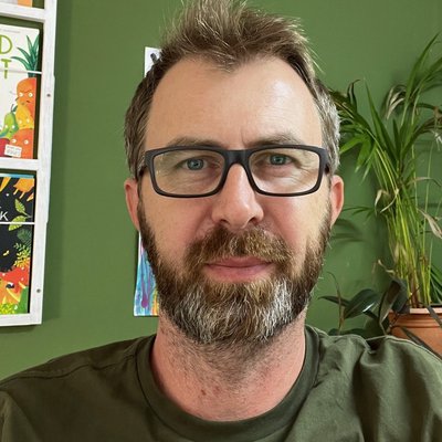 Alex Latimer, a white, middle-aged male author and illustrator. He wears glasses, and has facial hair.