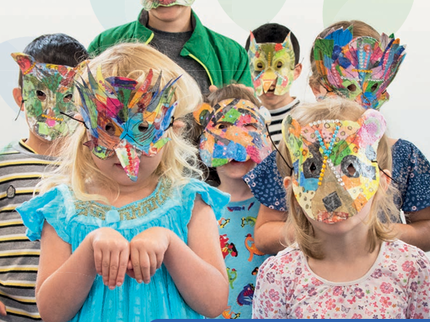 Annual review cover with an image of children in colourful masks
