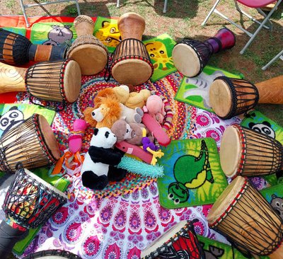 Photo of a circle of hand drums surrounding a pile of soft toy animals