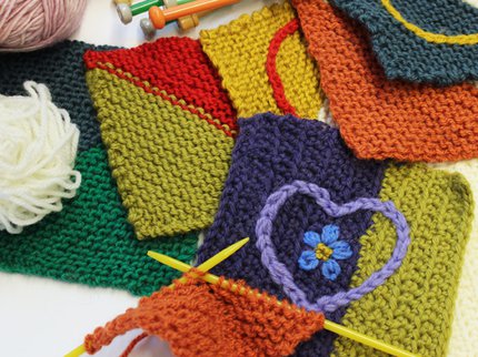 A photograph of knitted squares and knitting needles