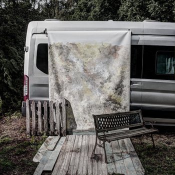 A van with a textured photography backdrop hung down the side