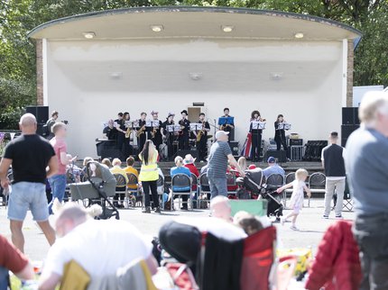 A group of musicians on stage with a crowd outside