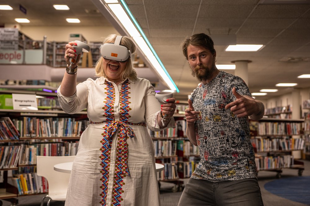 Two people wearing VR headsets in a library