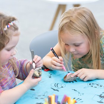 Two young girls taking part in a crafting activity.