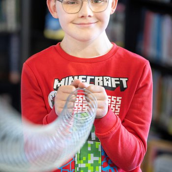A boy holding a slinky toy for a science trick.