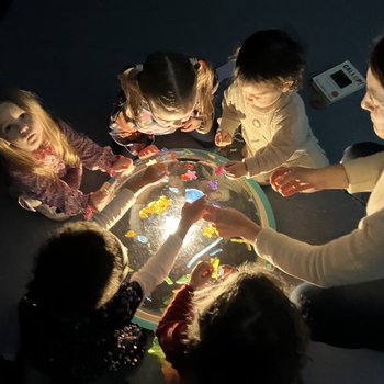 Girls around a dome exploring light and blocks