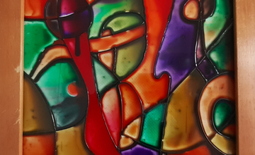 A framed tile of multicoloured glass sections painted