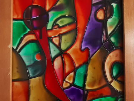 A framed tile of multicoloured glass sections painted