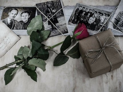 A collection of black and white family photos with a red rose and package