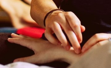 Hands using pressure points on wrist of someone else