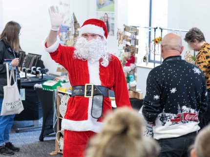Santa waving at shoppers at a Christmas market