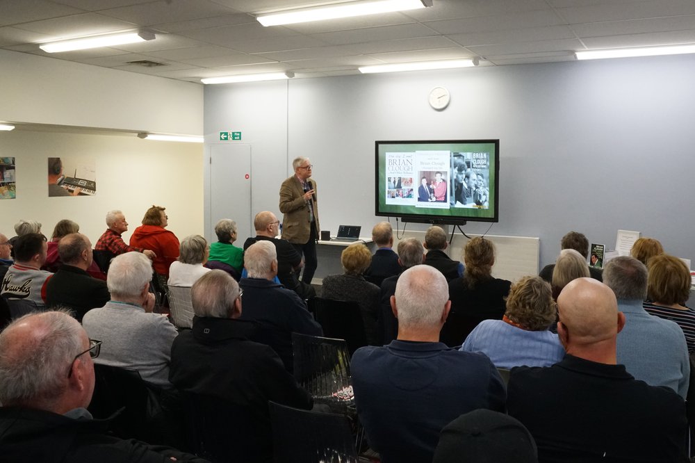 An audience listening to a talk by author and sports enthusiast Marcus Alton