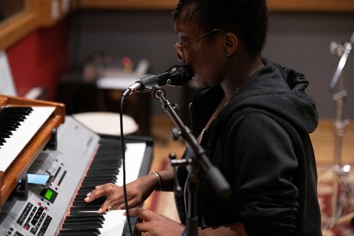 A female playing piano and singing