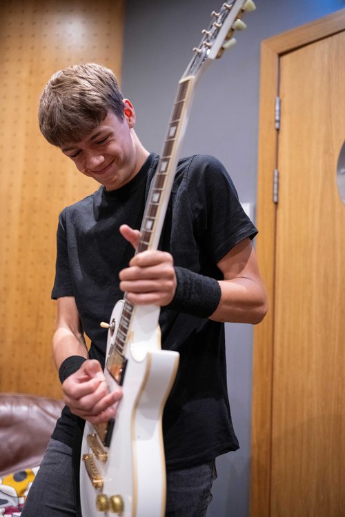 A young man playing an electric guitar