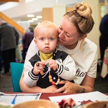 a mum with her baby taking part in some heritage crafts