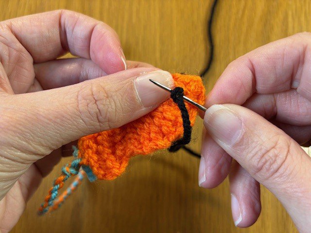 A yarn stitch behind a french knot