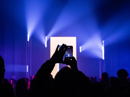 Back of head crowds with hands holding mobile phone