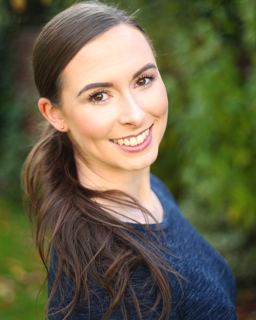 Megan Hooley wearing a blue top with a pony tail and long hair looking at the camera