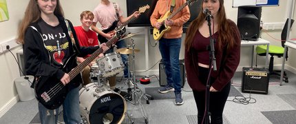 A group of four musicians in a studio room