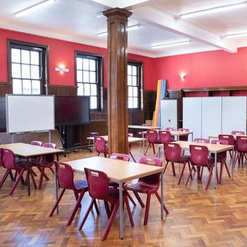 Large hall painted red set out with tables and chairs
