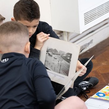 School students sat looking at an old photo of Ollerton