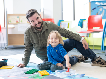 Parent and child playing with lego in the library