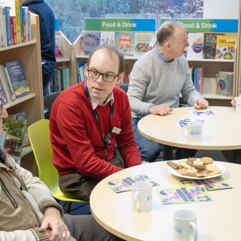 Group of people sat chatting and drinking tea at a Places of Welcome group