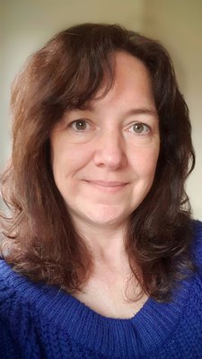 a selfie image of a brunette woman smiling