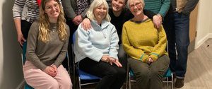 A group of mixed adults sit and smile