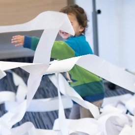 Child playing in and throwing till roll