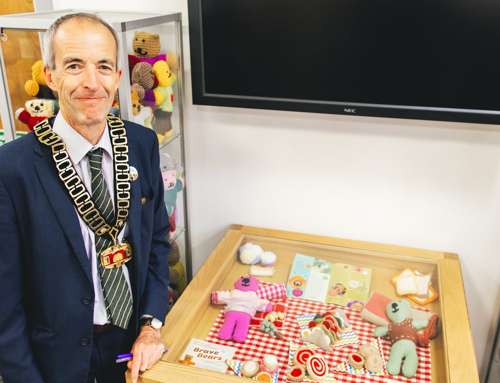 A close up of local Nottinghamshire County Council Counsellor with a glass box of knitted picnic items