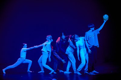 Six young dancers performing on stage with a blue light.
