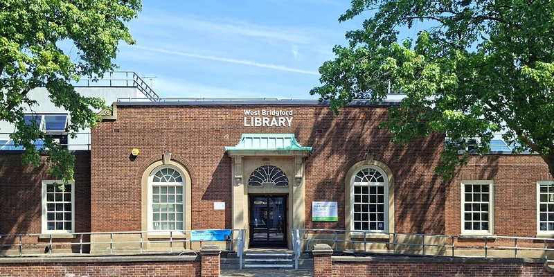 A photo of West Bridgford Library on a sunny day, surrounded by trees.