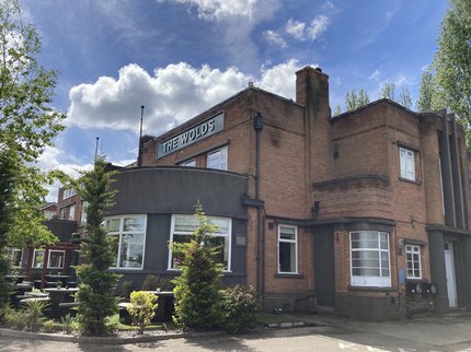 The exterior of the Wolds Pub in West Bridgford showing the entrance and outside seating area