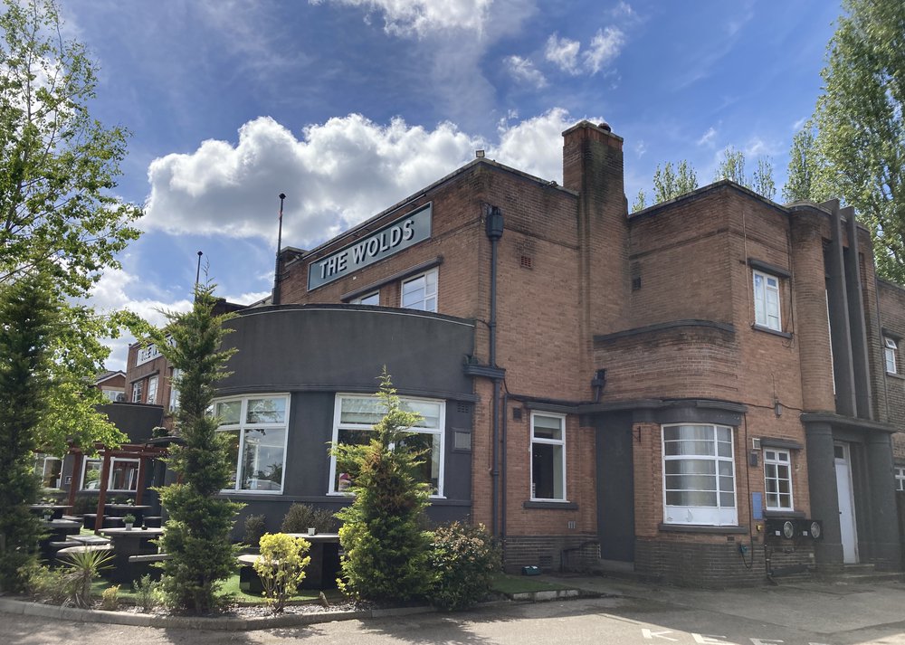 The exterior of The Wolds pub in West Bridgford showing the entrance and outside seating area