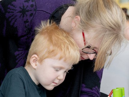 A child and an adult colouring together