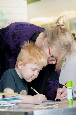 A child and an adult colouring together