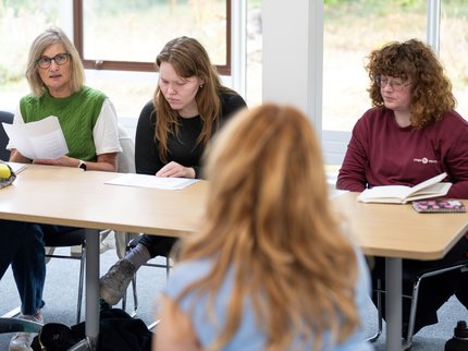 Three people taking part in a writing workshop
