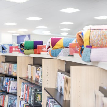 Library shelves with blankets on top