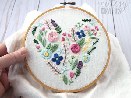 an embroidery hoop with embroidered flowers in the shape of a heart