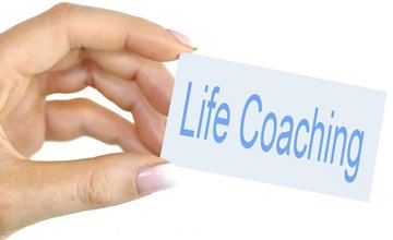 A hand holding a sign saying 'Life Coaching'