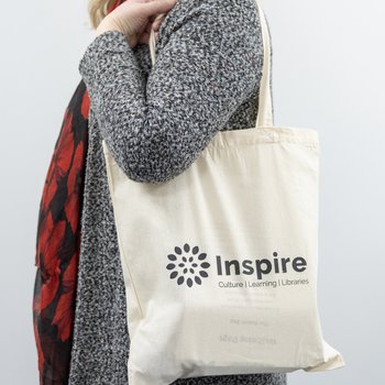 A woman holds a tote bag off her shoulder
