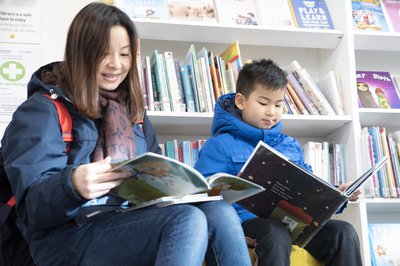 Parent and child reading together in the library