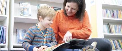 Parent and child reading together in the library