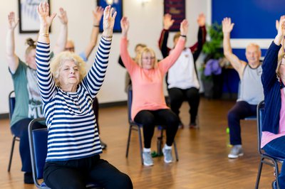 Photograph of a group of people taking part in chair based exercises