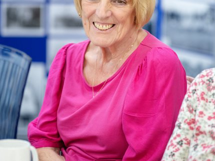 Smiling lady in pink at Places of Welcome group