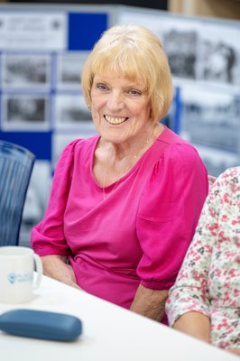 Smiling lady in pink at Places of Welcome group