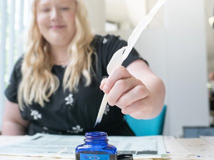 Woman writing with a quill pen